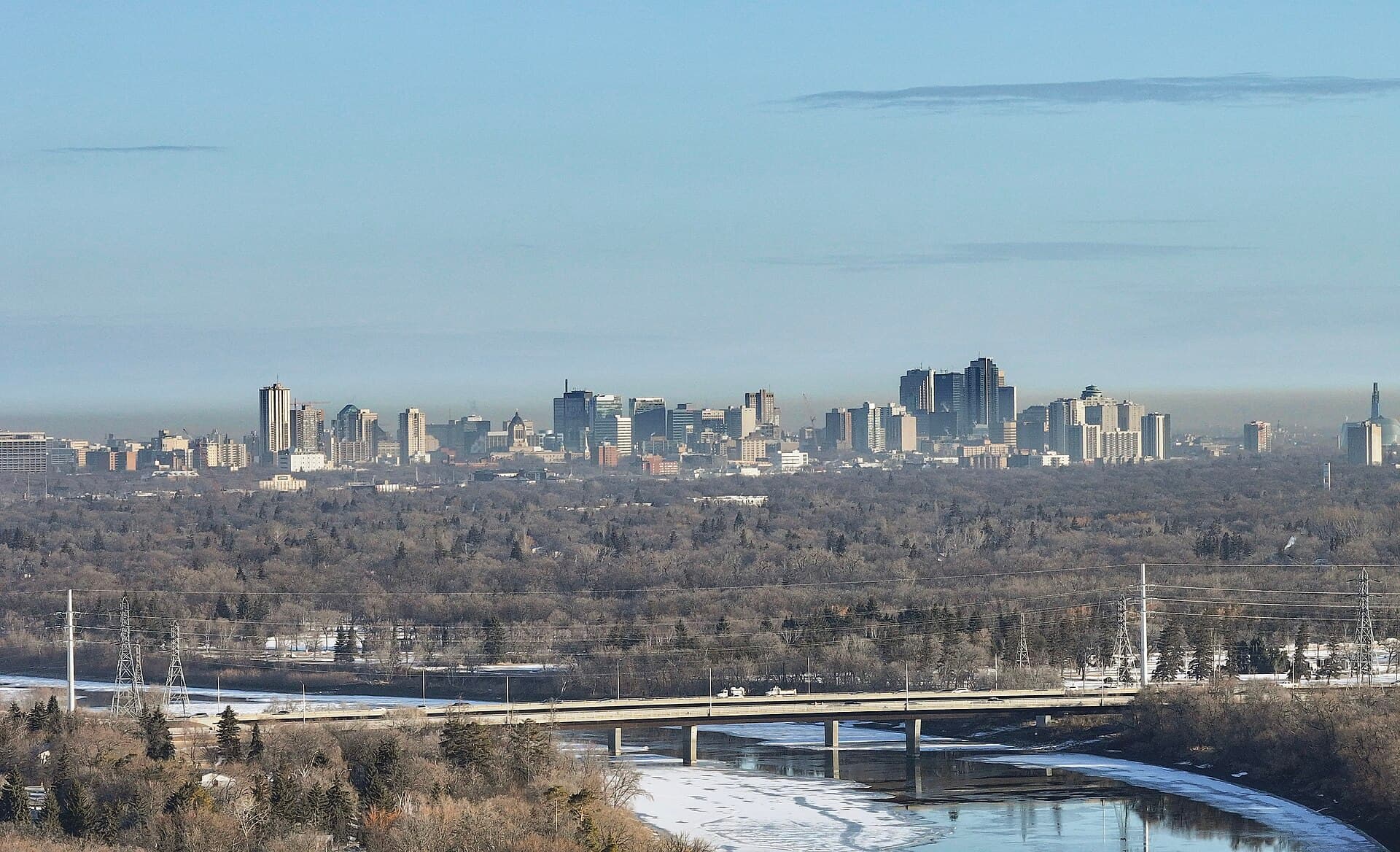 Winnipeg skyline seen across the tree-lined river valley