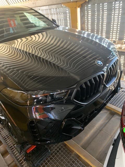 Front view of a customer's BMW X6 loaded inside an enclosed autorack rail car
